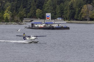 float plane taxiing past the floating Chevron station