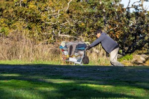 man pushes belongings in a cart