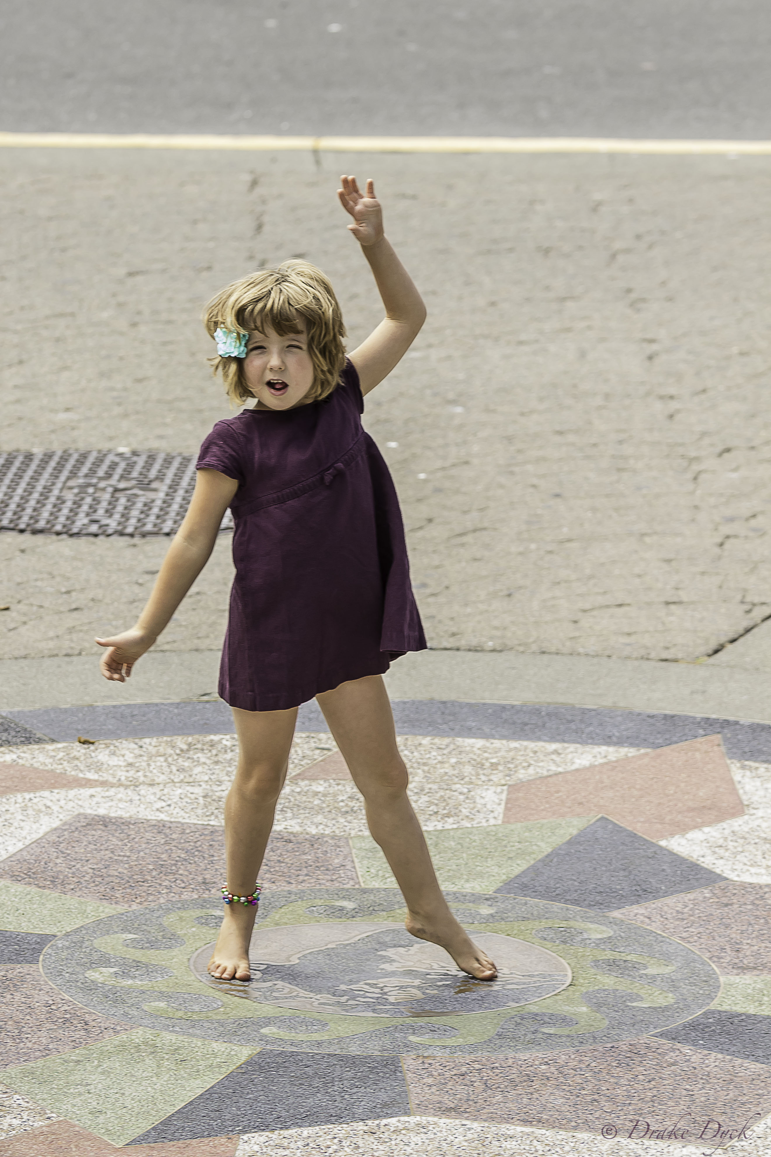 a little girl in a dress spins around in a circle