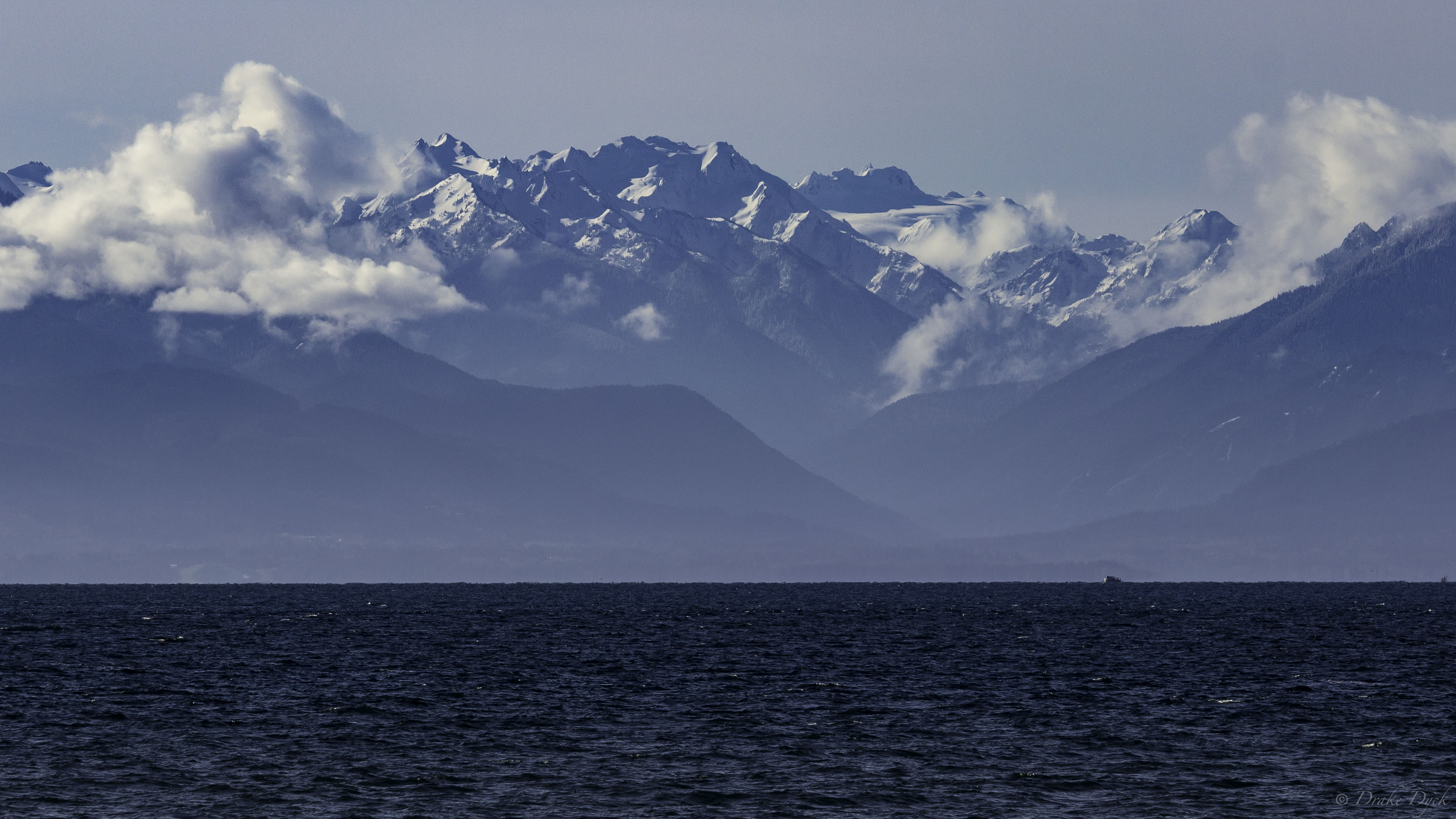 view from Ogden Point of the snow capped mountains and ocean