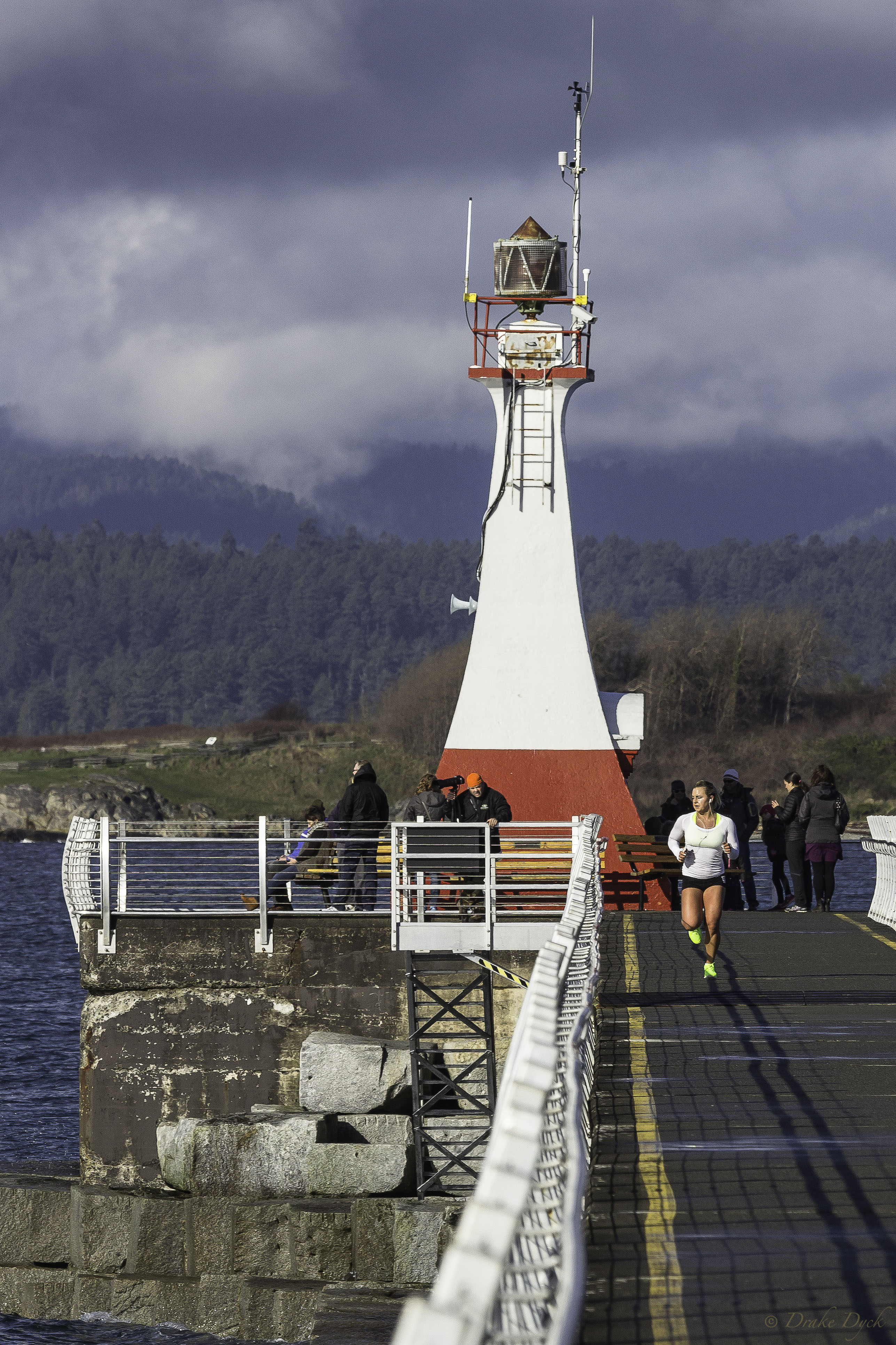 a jogger returns from the end of the breakwater near the lighthouse