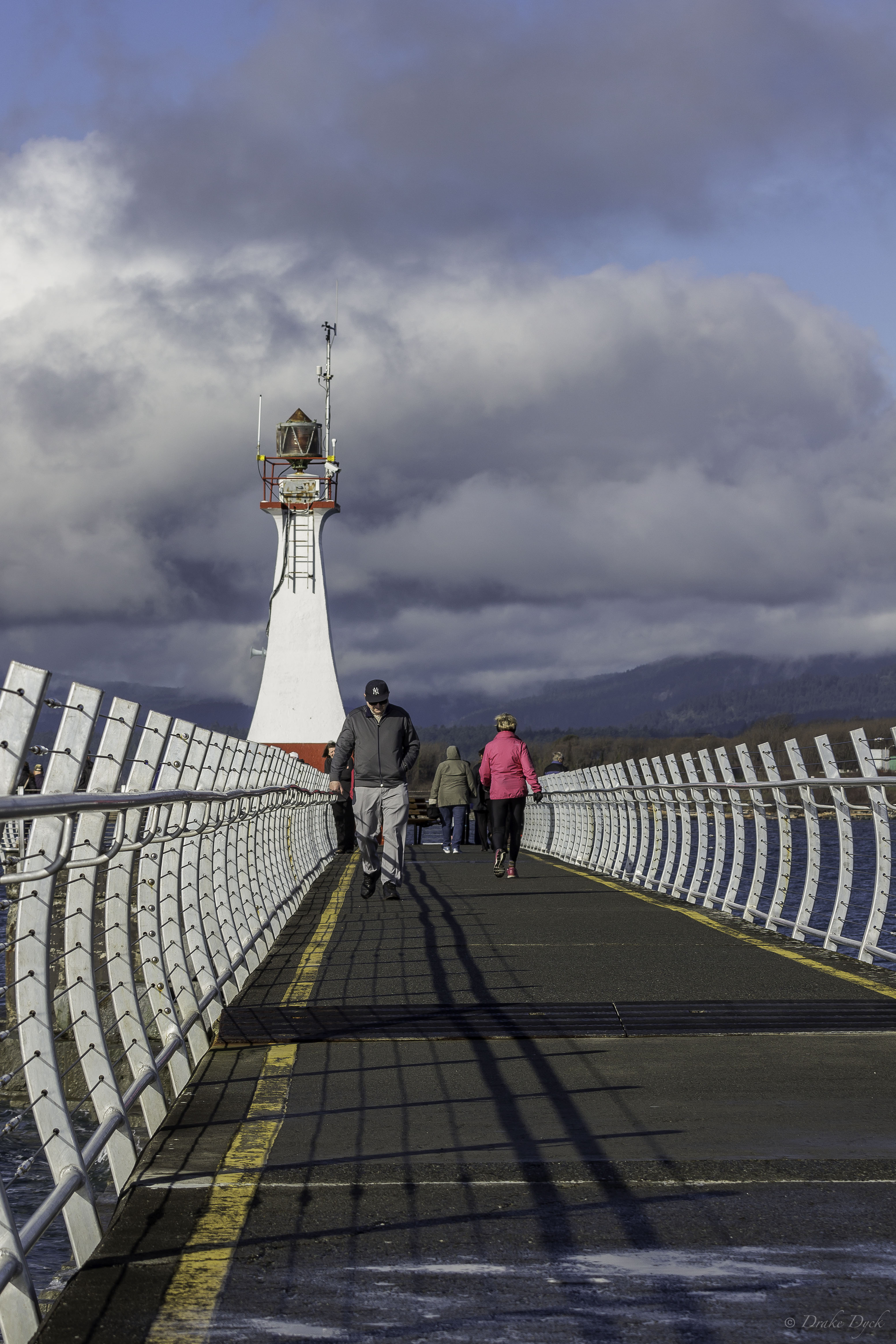 silver rails line the path to the lighthouse at the end of the breakwater
