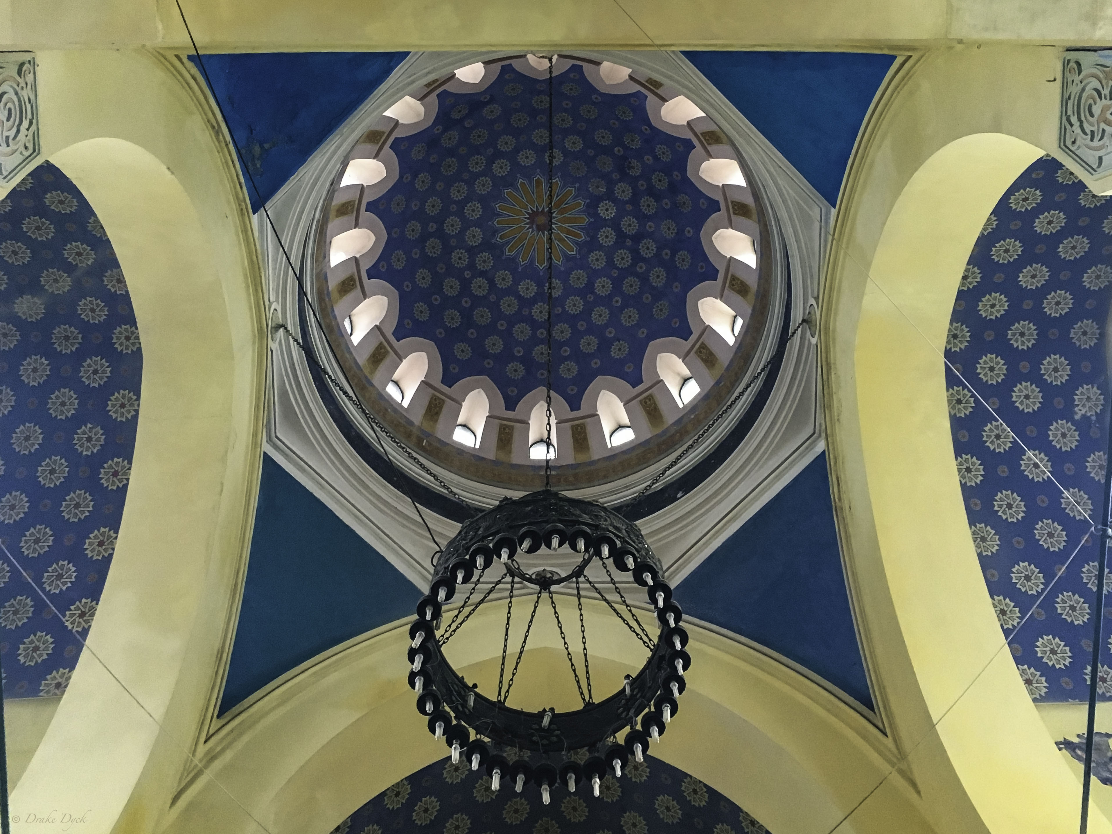 ornately decorated ceiling and chandelier inside the Carol I mosque