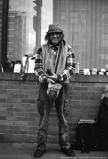 man standing with two hats