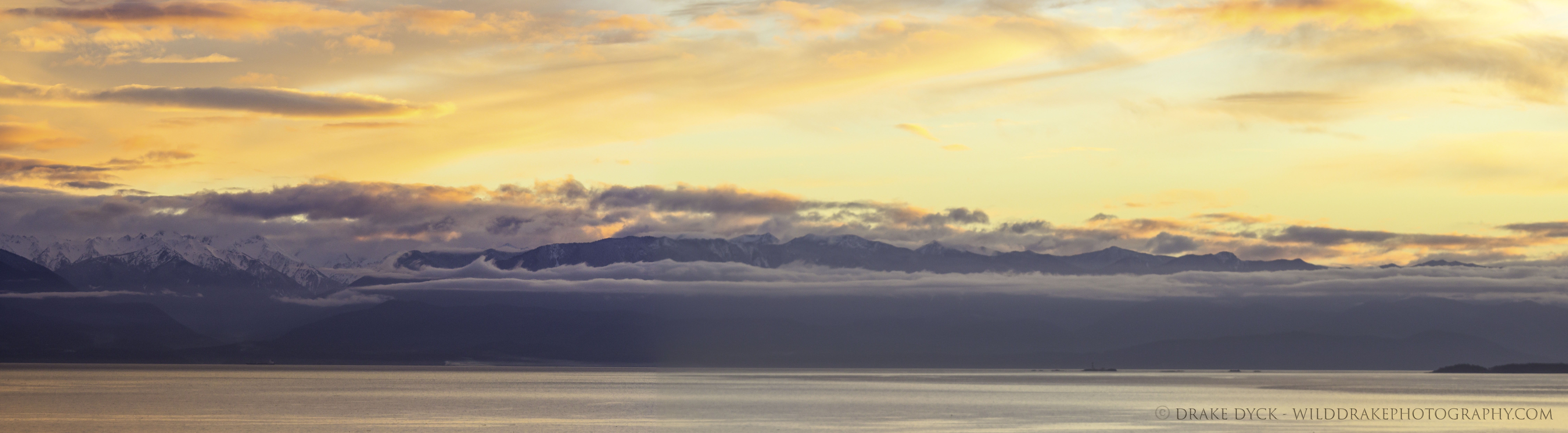 a cloudy mountain sunset over the ocean