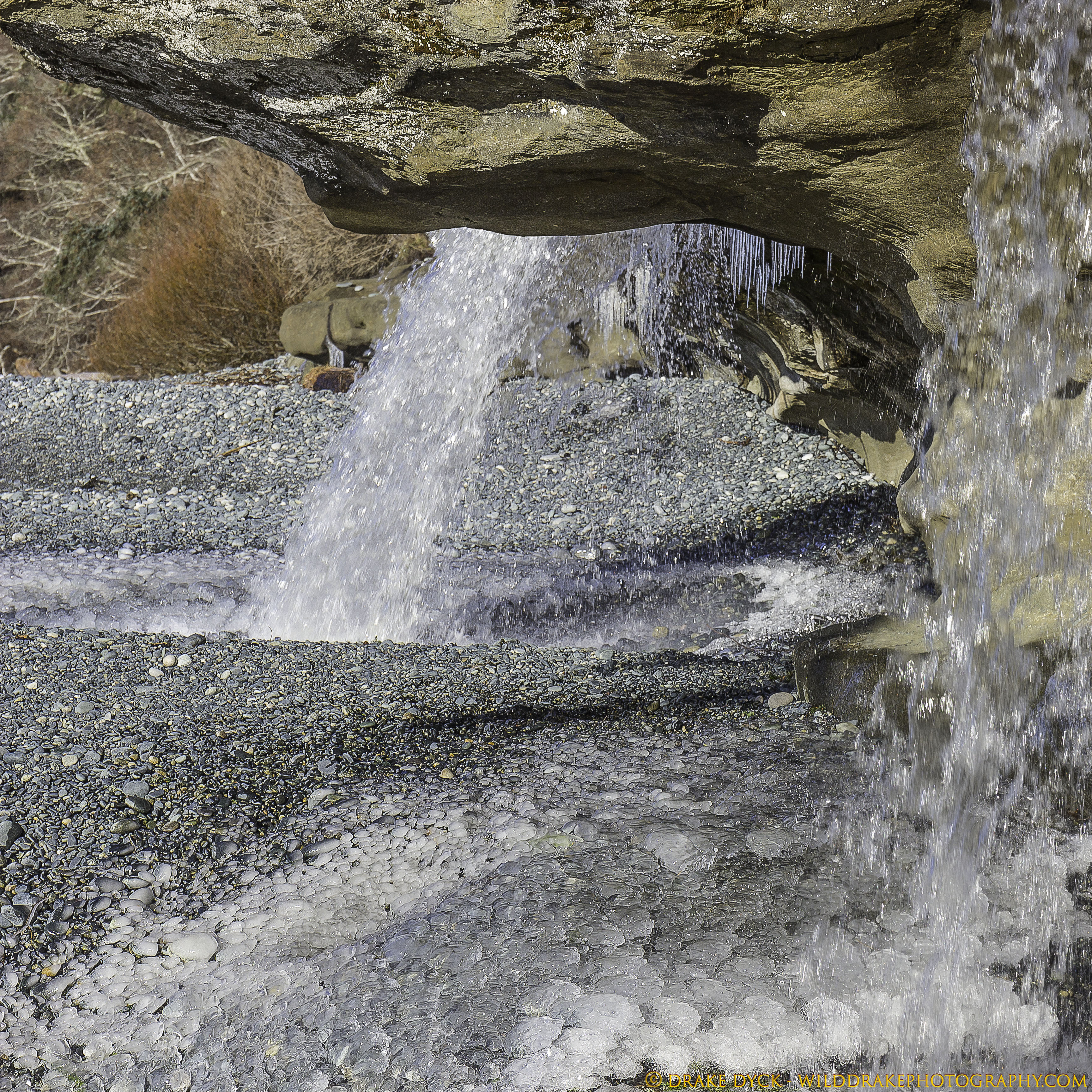 Waterfall on a frozen rocky beach