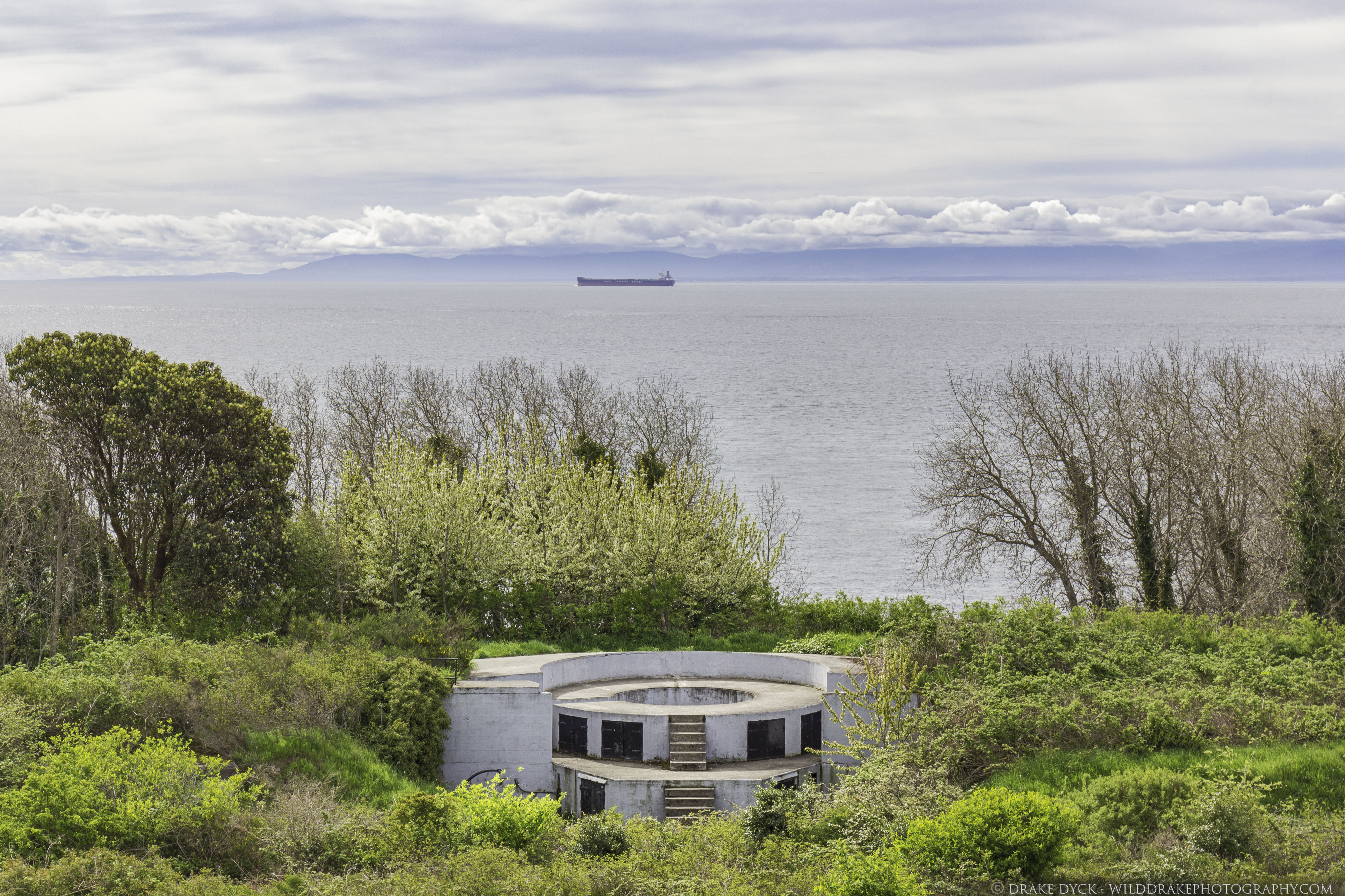 a naval gun emplacement overlooks a freighter at sea