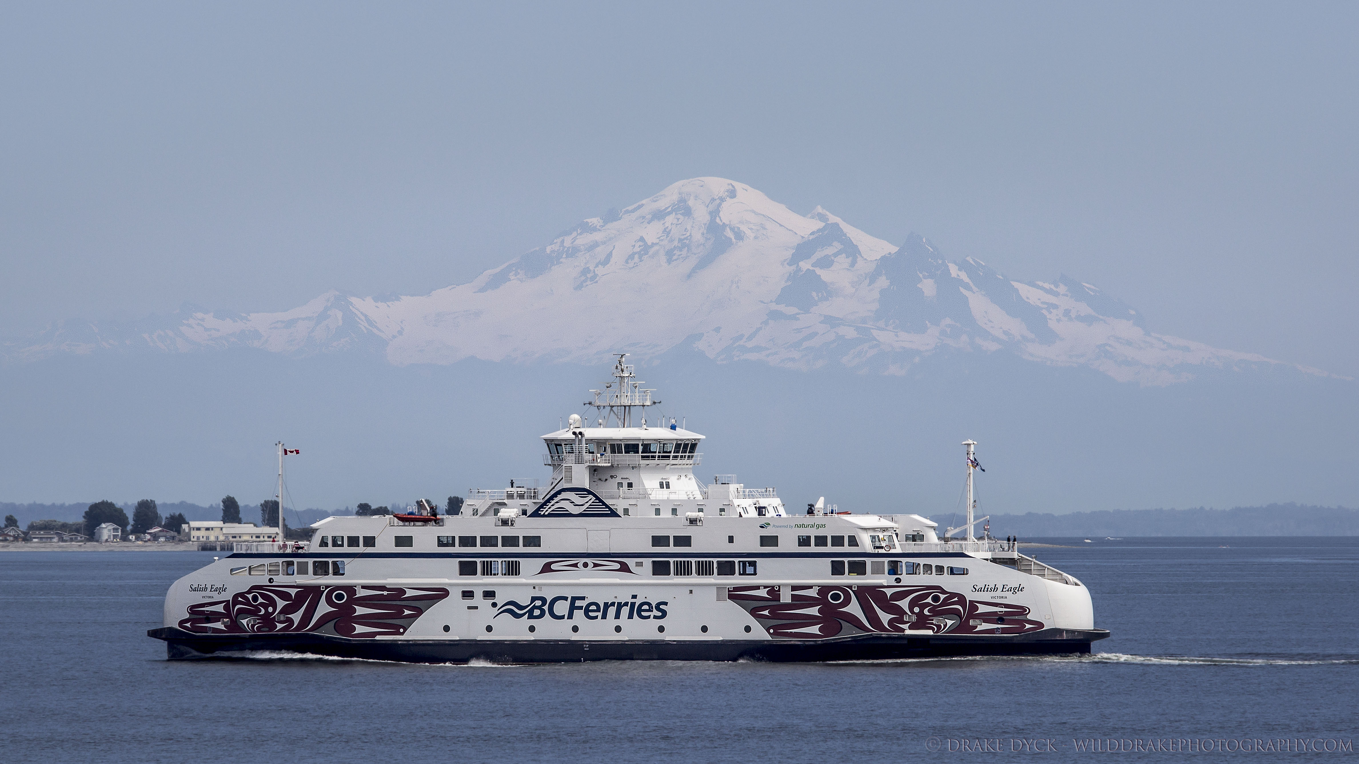 a BC Ferry crossing the Salish sea in front of a dormant volcano