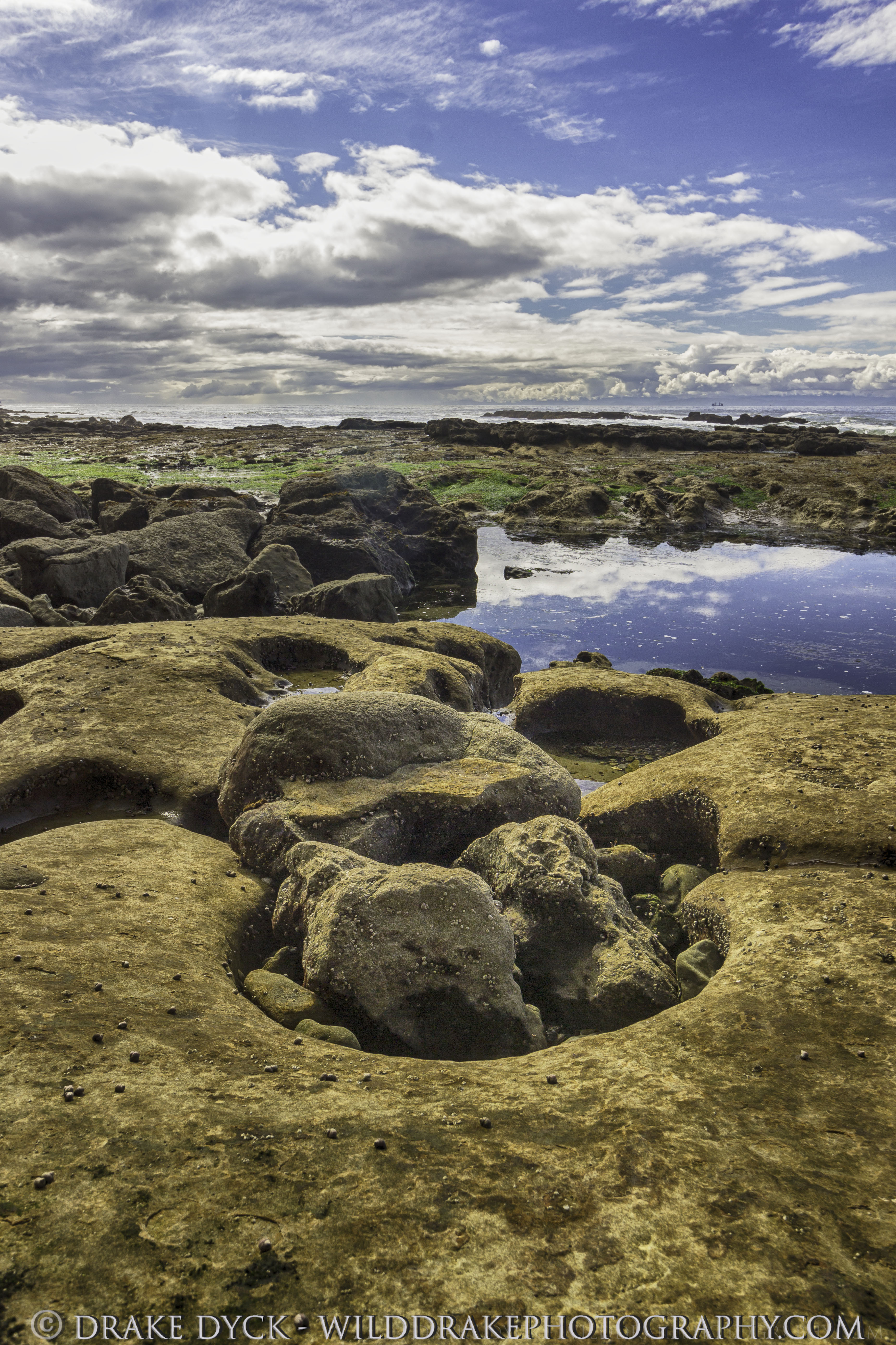 rocks potholes clouds and waves at the beach