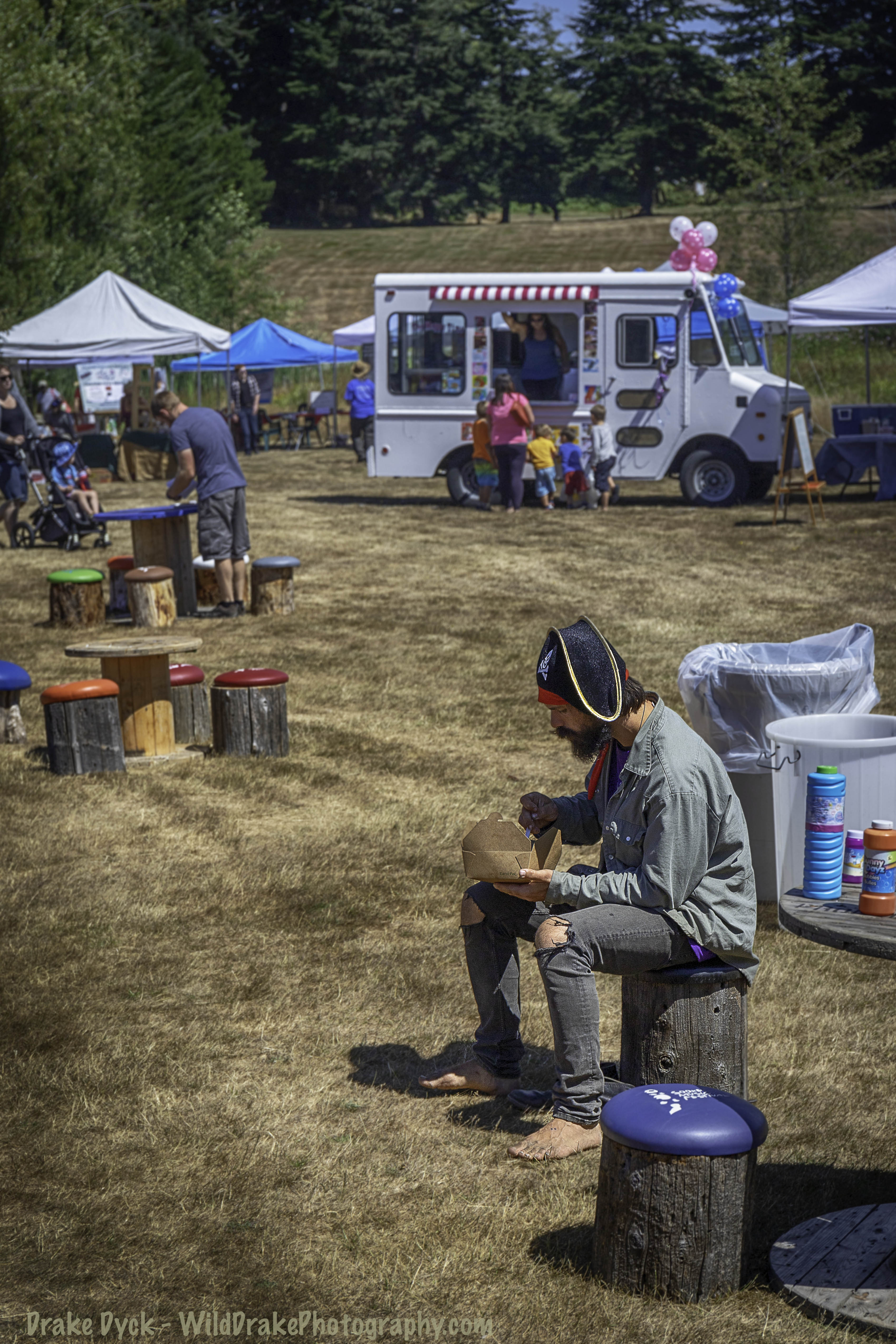 a man with a pirate hat eats a box of take out food